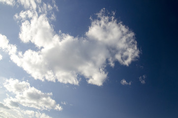 White fluffy clouds in deep blue summer sky