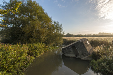 Fototapeta premium Ein vergessener Bunker der umgekippt im Wasser liegt