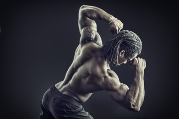Back of African American bodybuilder man, naked muscular torso, wearing boxer shorts, isolated on...