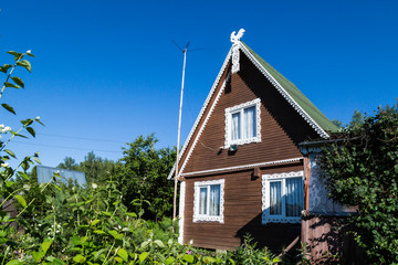Rustic brown house with white wood carvings on blue sky background