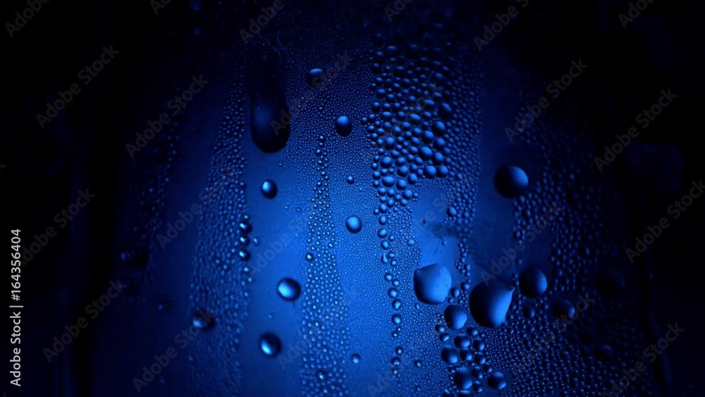 Aufkleber a drop of water on a glass close-up macro with sparkling bokeh on blue blurred background. abstract 