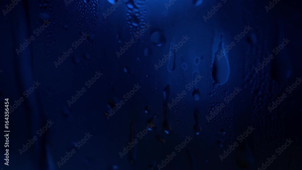 Aufkleber a drop of water on a glass close-up macro with sparkling bokeh on blue blurred background. abstract 