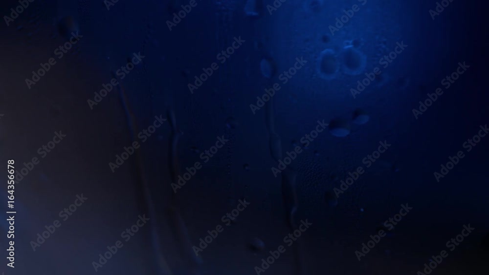 Poster a drop of water on a glass close-up macro with sparkling bokeh on blue blurred background. abstract 
