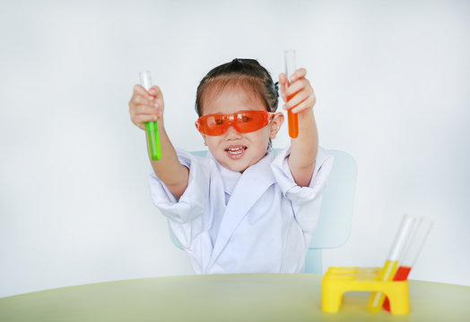 Asian child in scientist uniform holding test tube with liquid isolated on white background.
