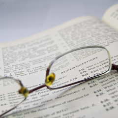 review questions, electronic engineering book reading with glass on open page