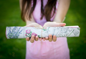 Young woman holding rolled table-cloth closeup