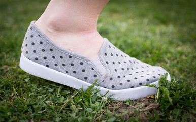 Woman is walking in grass, shoe with dots