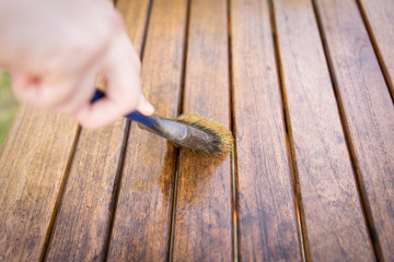 Paintbrush in hand and painting on wooden table