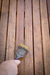Paintbrush in hand and painting on wooden table