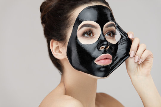 Woman Face Mask. Closeup Beautiful Girl Removing Black Mask