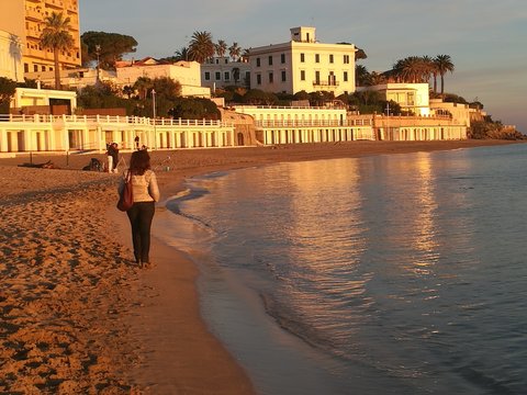 Donna che cammina al tramonto sulla piaggia di Santa Marinella nel Lazio in Italia