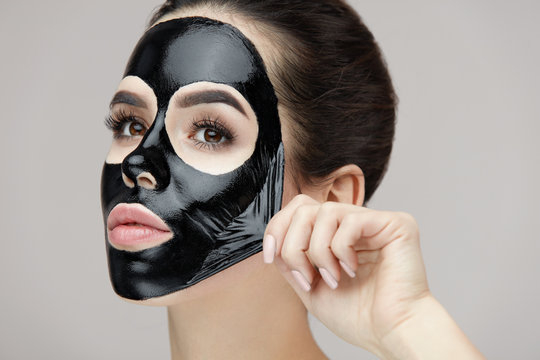 Woman Face Mask. Closeup Beautiful Girl Removing Black Mask