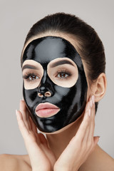 Woman Beauty Face Skin Mask. Girl Applying Black Peeling Product
