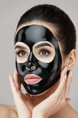Woman Beauty Face Skin Mask. Girl Applying Black Peeling Product