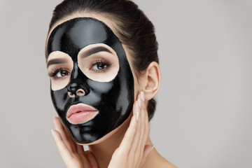 Woman Face With Natural Makeup And Black Peeling Mask On Skin