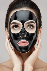 Woman Face With Natural Makeup And Black Peeling Mask On Skin
