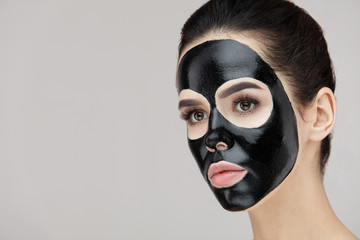 Beauty Face Black Mask. Woman With Black Cosmetic Mask On Skin