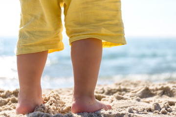 Fototapeta na wymiar Standing on the sand of the feet of a little boy closeup