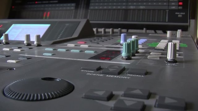 View of a mixing desk, view from the side with slowly changing focus from foreground to background