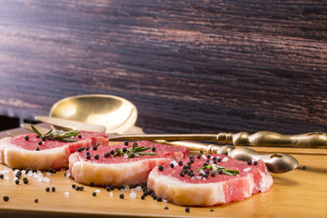 Steaks from raw meat on a wooden board.