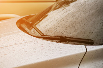 Windshield Wipers of a Metallic Gray Car with Sun Rays after Raining