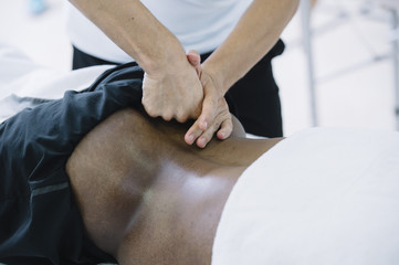 Naklejka premium The physiotherapist treating a man using equipment for radio therapy