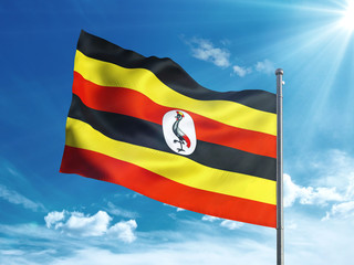 Uganda flag waving in the blue sky