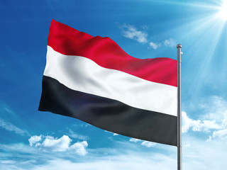 Fototapeta na wymiar Yemen flag waving in the blue sky