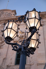 Fototapeta na wymiar Dreiarmiger Kandelaber als stimmungsvolle Straßenbeleuchtung vor Il-Burga de Kastija in Valetta