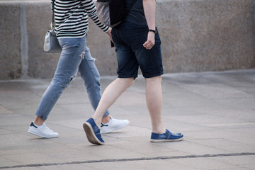 A guy and a girl are walking through the summer city