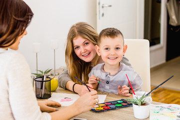 Fototapeta premium Portrait of little kids painting with mom in home