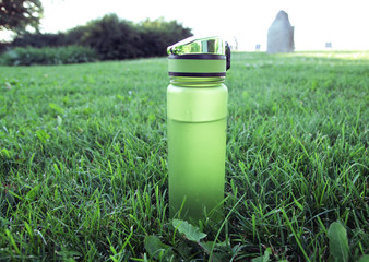 Bottle with water on grass