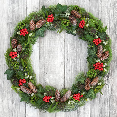 Christmas wreath decoration with holly, mistletoe, snow covered fir, blue spruce, ivy and pine...