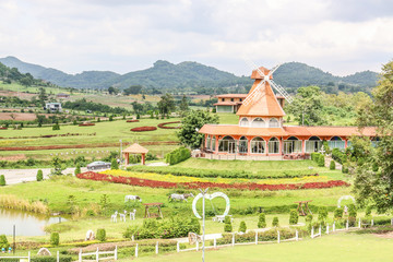 windmill and green field of grass and mountains background little dark sky