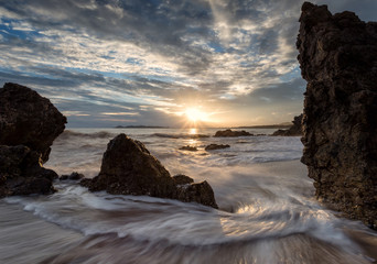 Fototapeta na wymiar stones in sea water on sunset background