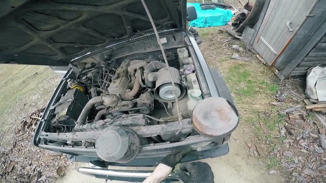 POV Man fumbling with the old machine in the engine compartment