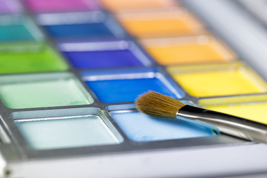  Palette Of Blue And Yellow Eye Shadow And Makeup Brush