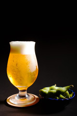 Glass of beer with edamame on black background
- 164373085