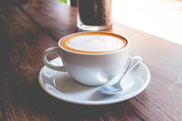 hot coffee mocha with foam milk in vintage cafe(vintage effect)