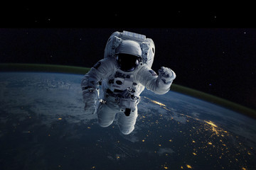 Obraz na płótnie Canvas Astronaut in outer space. Background Earth. Elements of this image furnished by NASA