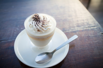 Delicious milk pudding with grated chocolate over napkin on wood table