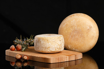 Artisan cheese on black background.