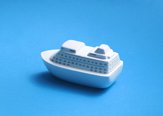 Toy passenger ship on blue background