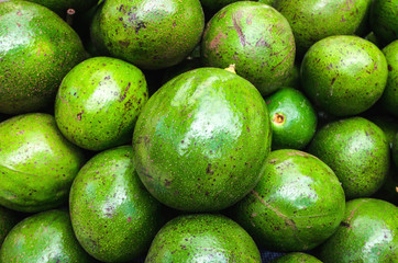 Avocado background. Fresh green avocado on a market stall. Food background