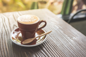 Top view of cappuccino hot coffee on wooden table background in a coffee shop.