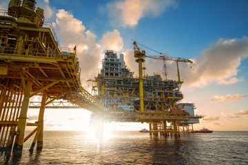Offshore oil  platform in sunset or sunrise time. Construction of production process in the sea. Power energy of the world.