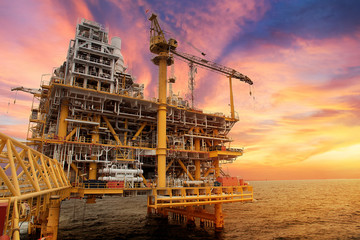 Offshore construction platform for production oil and gas. Oil and gas industry . Production platform and operation process during sunset time