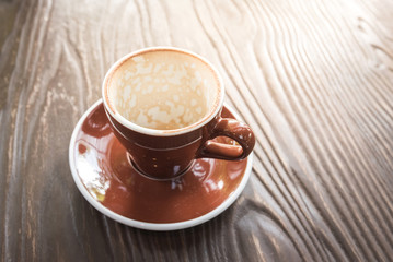 Empty coffee cup after drinking on wooden table in the morning.