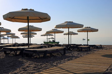 Parasole i leżaki na plaży wzdłuż morza, Rodos w Grecji.