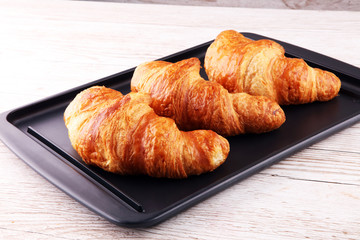 freshly baked croissants on white board, bakery concept